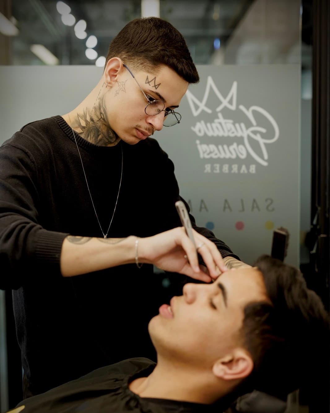 Gustavo Derussi fazendo o acabamento de um cliente com navalha
