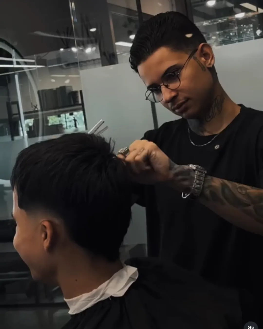 Gustavo Derussi cortando o cabelo de um cliente na barbearia, em Joinville