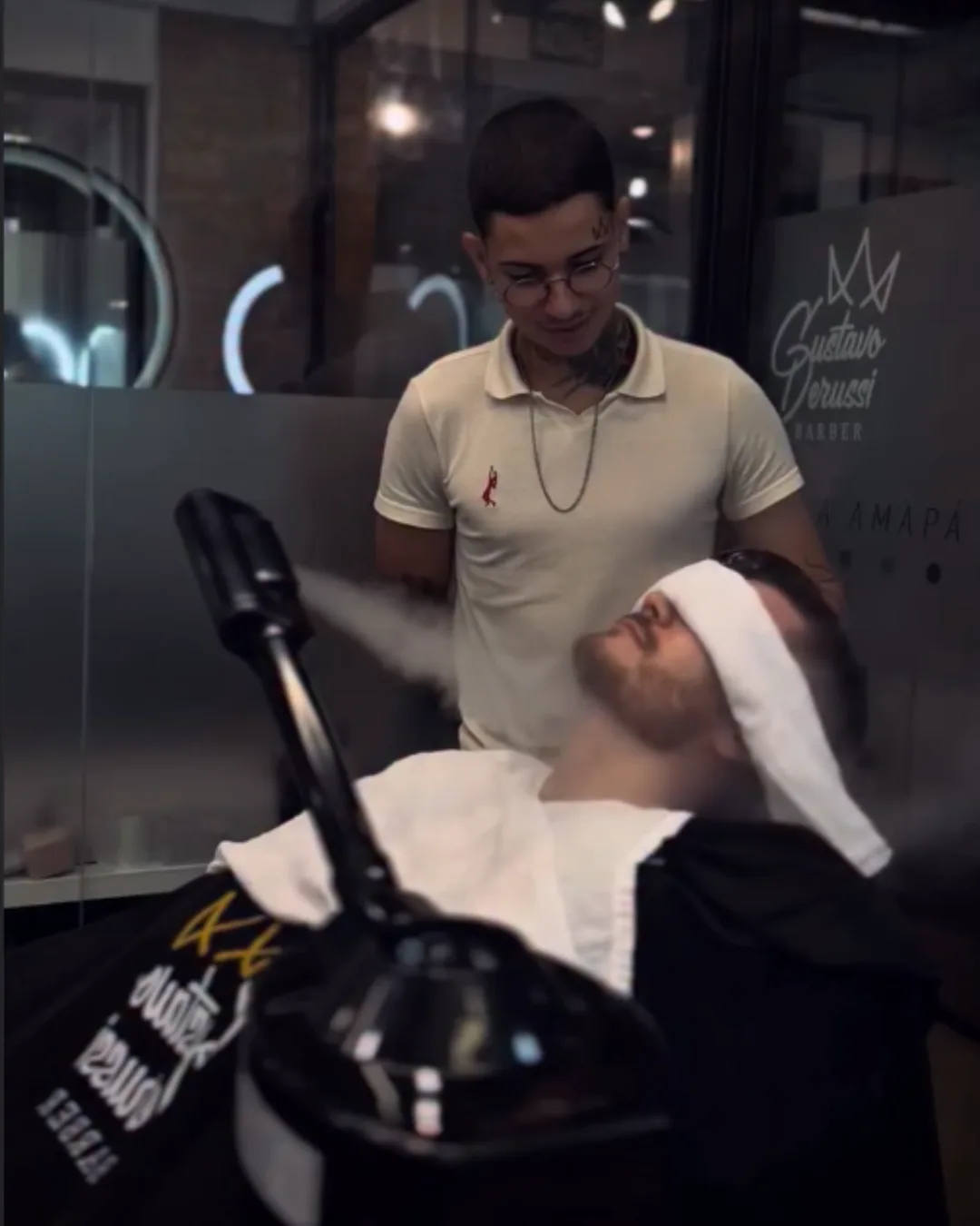 Cliente recebendo vaporização facial na barbearia de Gustavo Derussi